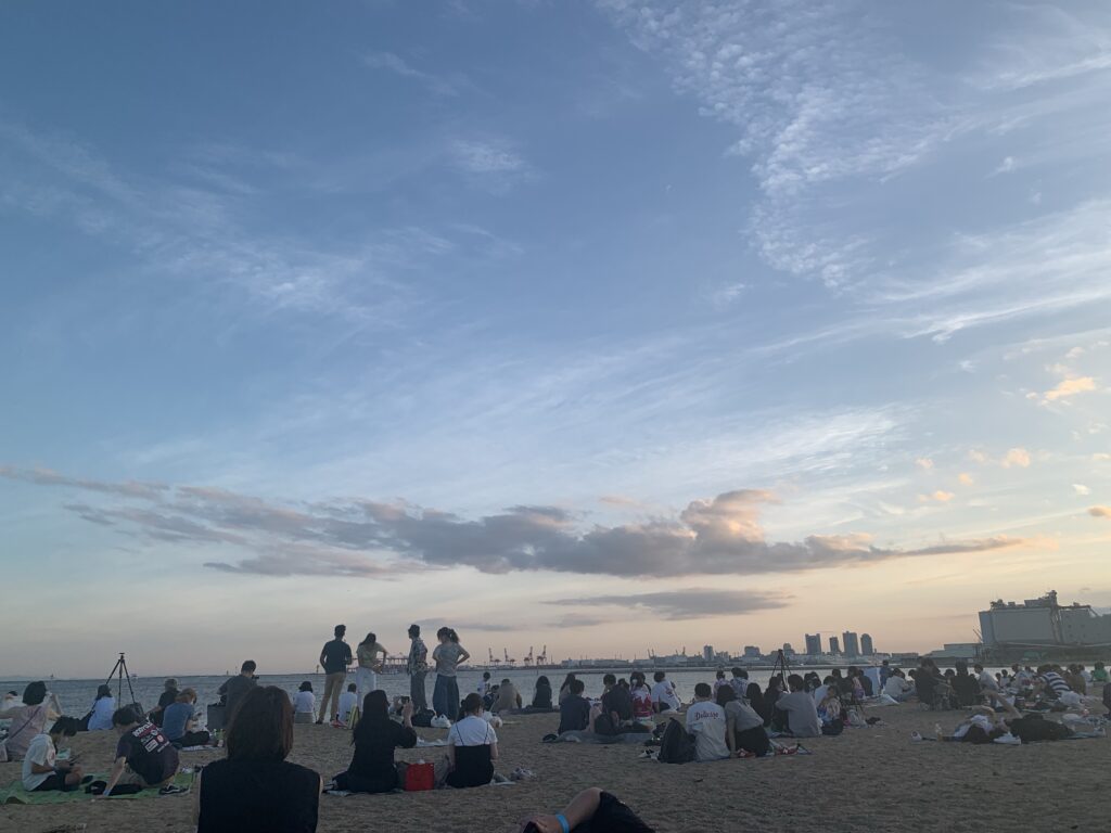 芦屋サマーカーニバル 砂浜に人が座っている